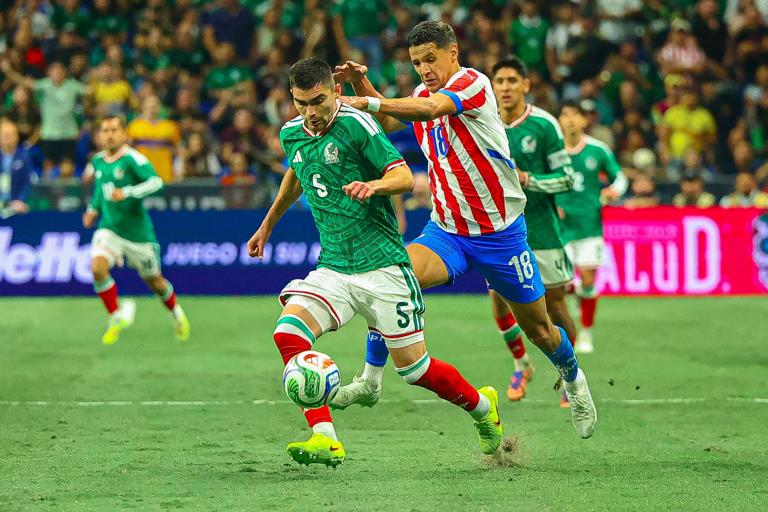 Johan V&aacute;squez and Alex Arce contest possession in the match between Mexico and Paraguay