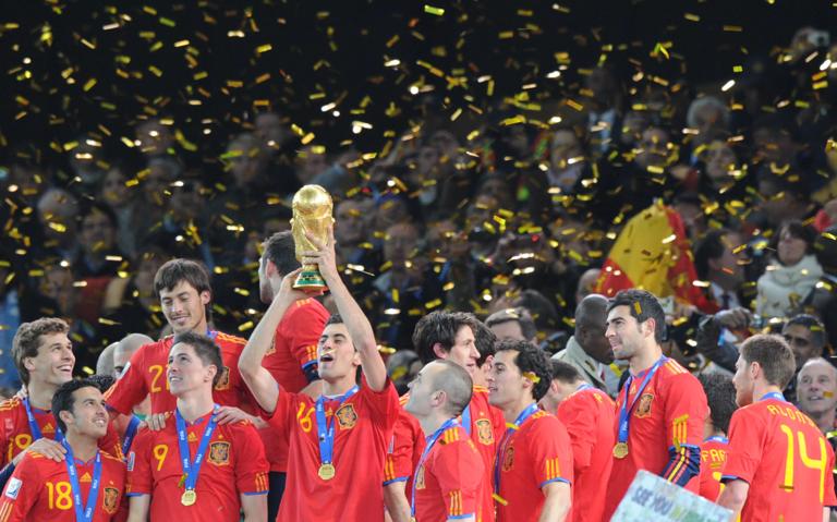 Spain's midfielder Sergio Busquets raises the trophy after the award ceremony following the 2010 FIFA football World Cup between the Netherlands and Spain on July 11, 2010 at Soccer City stadium in Soweto, suburban Johannesburg. Spain won 1-0. NO PUSH TO MOBILE / MOBILE USE SOLELY WITHIN EDITORIAL ARTICLE       AFP PHOTO / PEDRO UGARTE (Photo credit should read PEDRO UGARTE/AFP via Getty Images)